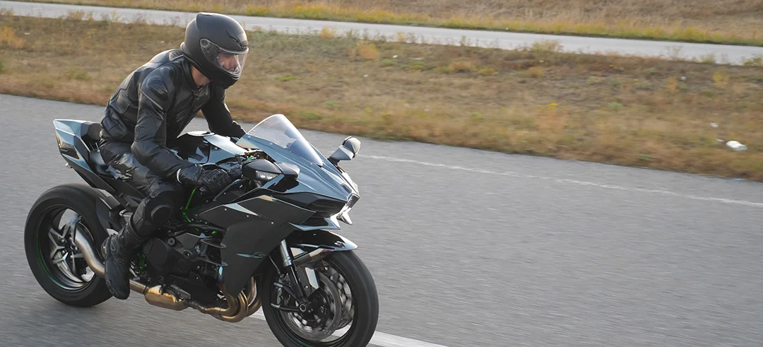 Motorista circulando con su moto por una carretera